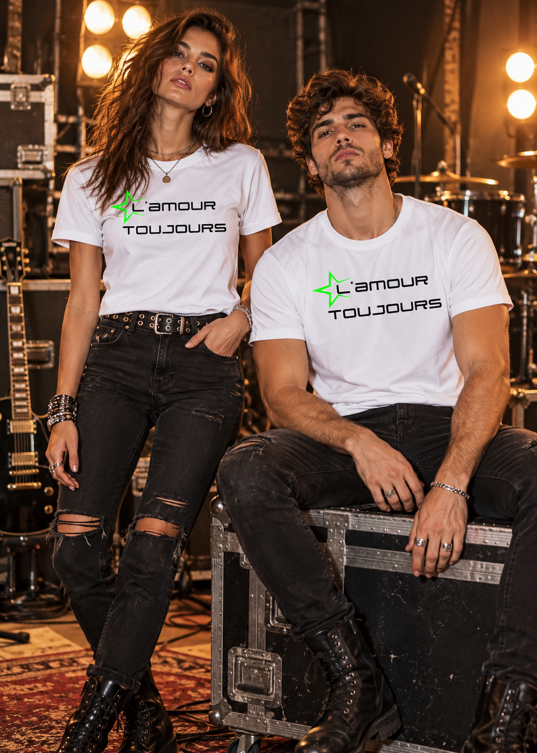 Frau und Mann tragen weiße Unisex T-Shirts mit schwarzem L'amour Toujours Schriftzug und neongrünem Stern im rockigen Musikstudio.