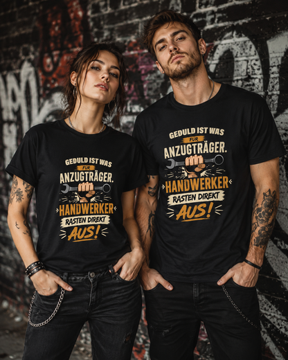 Frau und Mann im rockigen Stil tragen ein schwarzes Handwerker-T-Shirt mit Schraubenschlüssel-Motiv und dem Spruch „Geduld ist was für Anzugträger. Handwerker rasten direkt aus!“ vor einer Graffitiwand.