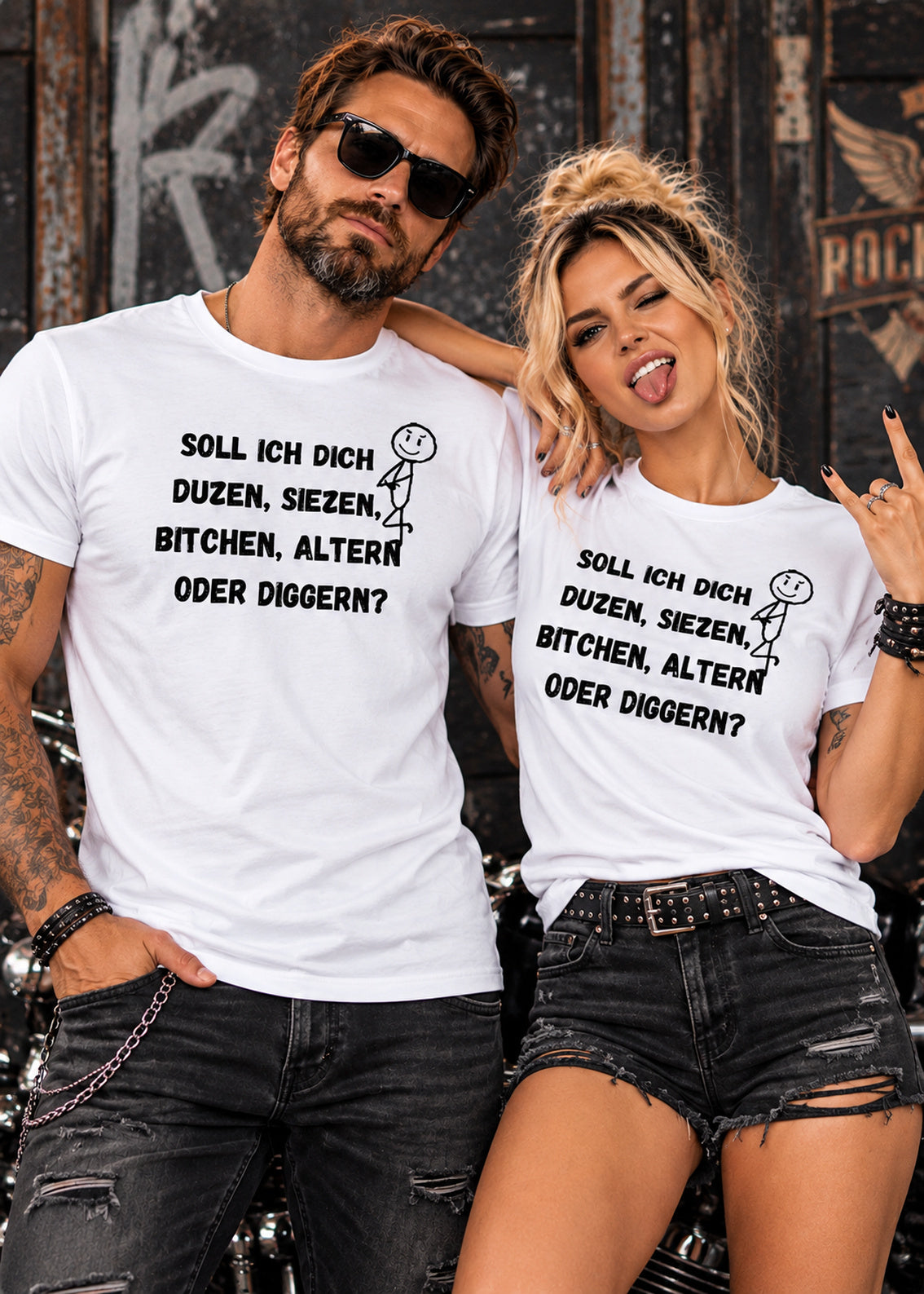 Frau und Mann im rockigen Style tragen weiße T-Shirts mit schwarzem Sprüche-Aufdruck und kleinem Strichmännchen vor einer Graffitiwand.